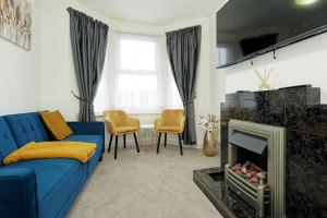 查塔姆Immaculate 3-Bed House in Chatham的客厅设有蓝色的沙发和壁炉