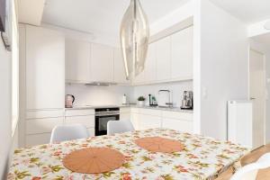 卑尔根Bergen's Finest: Sleek Oasis with Two Bedroom的白色的厨房配有桌子和白色橱柜