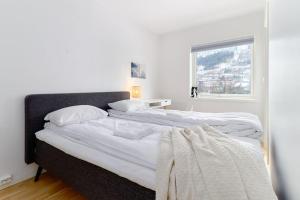 卑尔根Bergen's Finest: Sleek Oasis with Two Bedroom的白色卧室设有两张床,配有窗户