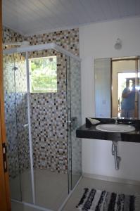 伊利亚贝拉Suítes Paquetá Ilhabela的一间带玻璃淋浴和水槽的浴室
