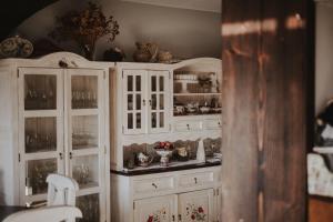韦特利纳Dom Malowany的一间厨房,配有白色橱柜和餐具