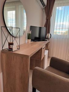 普里什蒂纳Hotel Uniluxury的一张桌子,里面配有电视和镜子