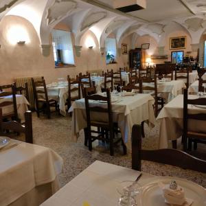 佩斯科克斯坦佐Locanda Tre Frati的餐厅配有桌椅和白色的桌布