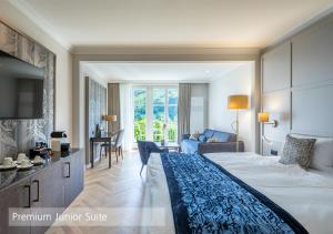 伦克Lenkerhof gourmet spa resort - Relais & Châteaux的一间带大床的卧室和一间客厅