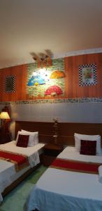 昆岛Homstay Thanh Sơn的一间卧室设有两张床和一个带遮阳伞的墙壁。