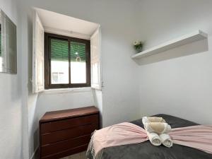 马德里Ile Aina Exterior Nuevo Peña的一间卧室配有带梳妆台和窗户的床。