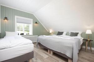惠拉盖尔济SKYR Guest House的两张床位于带绿色和白色墙壁的客房