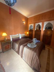 马拉喀什Riad Dar Teranga Hotel & Spa的一间卧室配有两张床,并备有毛巾