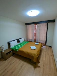 索非亚Business and Leisure apartments in Mladost 2 with FREE Garage的一间卧室配有一张带绿色棉被的床