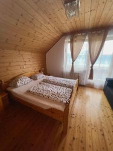 RothenthurnMentebauer Traudi's Ferienhof的木制客房内的一张大床,设有窗户