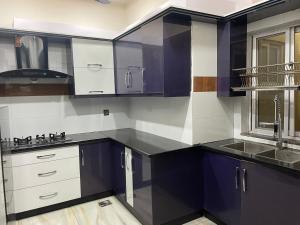 拉瓦尔品第BAHRIA HOLLIDAY HOME的厨房配有紫色和白色的橱柜和水槽