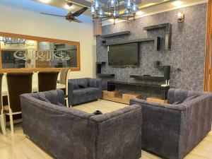 拉瓦尔品第BAHRIA HOLLIDAY HOME的客厅设有两张沙发和一个壁炉