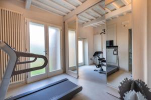 蒙特瓦尔基Dependance Villa Sassolini的一间带跑步机和镜子的健身房