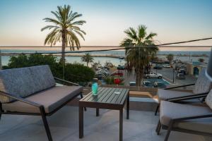 圣加利尼Cove Luxury Suites的阳台配有桌椅,享有海港的景致。