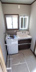 彦根市Villa Hikone Castle的一间带水槽和镜子的浴室以及一台洗衣机