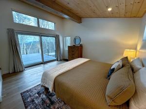 伯利恒1B Contemporary cabin in magnificent setting, luxury and comfort, hot tub, AC!的一间卧室设有一张大床和一个大窗户