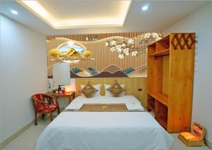 宁平TamCoc Golden Shine Homestay的一间卧室配有一张床和一张桌子及椅子