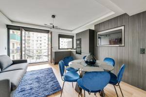 巴黎181 One Suite - Superb apartment in Paris.的客厅配有桌子和蓝色椅子