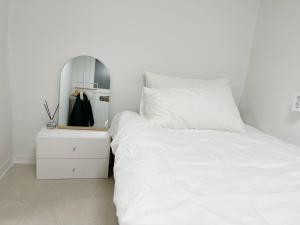 首尔Goyo in Seongsu的卧室配有白色床和床头柜