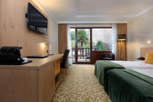 尼韦勒Hotel Restaurant Van Der Valk Nivelles-Sud的酒店客房配有一张床和一张书桌及一台电视
