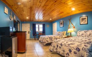 埃尔斯沃思白桦树汽车旅馆 、的一间卧室设有两张床和木制天花板