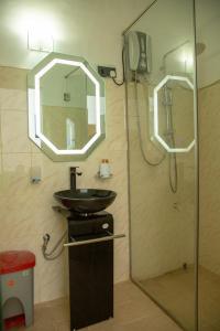 康提TIKI TAKA的浴室配有盥洗盆和带镜子的淋浴