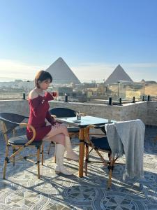 开罗Tuya Pyramids View的坐在桌子上的女人,用玻璃