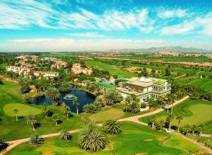马拉喀什Golf Club Rotana Palmeraie的享有高尔夫球场和度假村的空中景致
