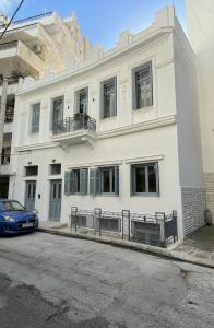 比雷埃夫斯Piraeus art deco apartment的前面有一辆汽车停放的白色建筑