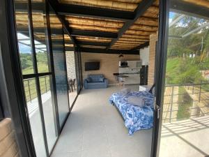 瓜塔佩Springfield Eco-Suites Guatapé的客厅设有滑动玻璃门,享有风景。