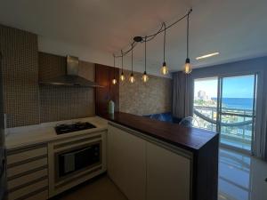 萨尔瓦多Apartamento Vista Mar aconchegante no Rio Vermelho的厨房配有带炉灶的柜台和窗户。