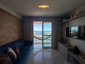 萨尔瓦多Apartamento Vista Mar aconchegante no Rio Vermelho的客厅设有蓝色的沙发和大窗户
