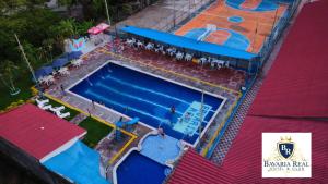 亨达Bavaria Real Hotel & Club的游泳池的顶部景色,周围的人坐在游泳池周围