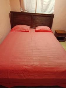 萨莱比梅Vacances agréables c'est ici的一张红色的床,上面有两个红色的枕头