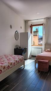 皮诺拉瓦Casa vacanze da Linda的一间卧室设有两张床、一张桌子和一个窗口。