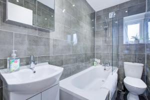 伦敦Wonderful Two-Bedroom Apartment的浴室配有盥洗盆、卫生间和浴缸。