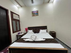 马图拉Vraj waas的一间卧室配有一张带两个天鹅的床
