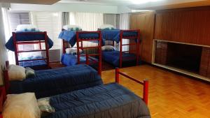 门多萨645 Hostel的带4张双层床和沙发的客房