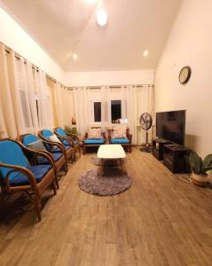 利安Omma's Beach house的客厅配有椅子、桌子和电视