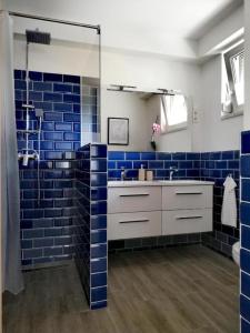 巴拉通雷勒Happy Apartments的浴室设有蓝色瓷砖墙壁和水槽