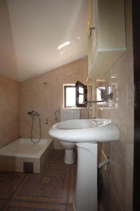 苏托莫雷Magnolia rooms and apartments的浴室配有盥洗盆、卫生间和浴缸。