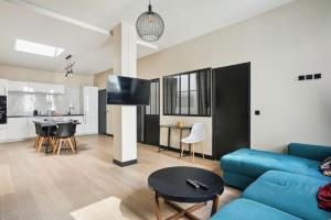 巴黎189 Suite Nine - Superb apartment in Paris的一间带蓝色沙发的客厅和一间厨房