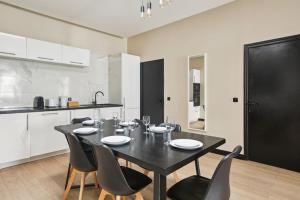 巴黎189 Suite Nine - Superb apartment in Paris的厨房里摆放着一张黑桌子和椅子
