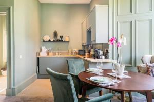 佩斯利Boutique Home Stay - Bliss Studio的厨房以及带木桌和椅子的用餐室。