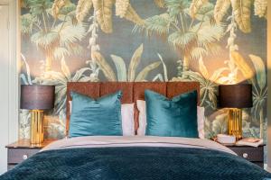 佩斯利Boutique Home Stay - Bliss Studio的一间卧室配有一张带蓝色枕头的床和热带壁纸