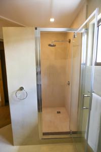 马埃岛沃里尔旅馆的浴室里设有玻璃门淋浴