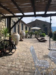 San Noto casina di caccia con piscina riscaldata的一个带椅子和桌子的庭院和一座建筑