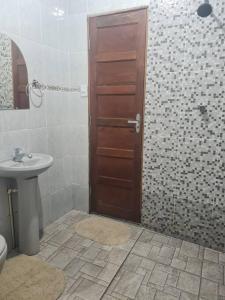马卡帕casa de praia的一间带水槽和木门的浴室