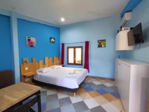 维特拉克塔里豪宅酒店的一间卧室配有一张蓝色墙壁的床和电视