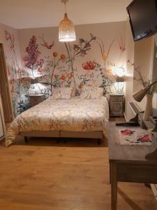 FlocourtFlopre chambre d'hote的卧室配有一张墙上鲜花的床